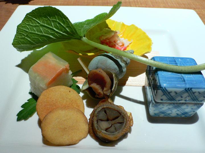 P1070385.JPG - 前菜　左下から、くわい煎餅、サーモンの押し寿司、蟹の土佐酢、つぶ貝、八幡巻き、器の中に合鴨のロース